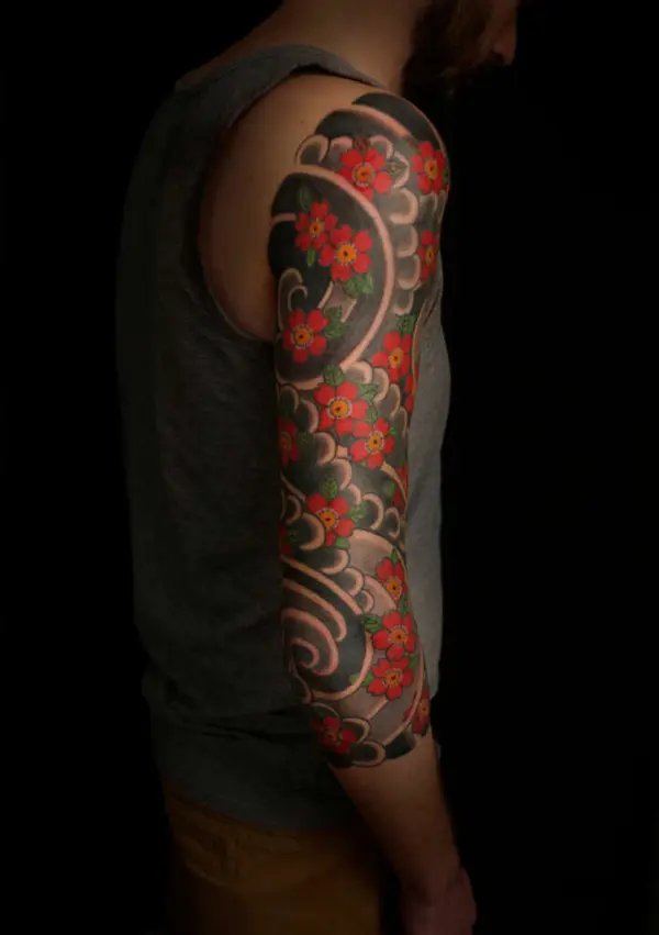 Tatouage Wabori avec fleurs de cerisier et vent sur le bras